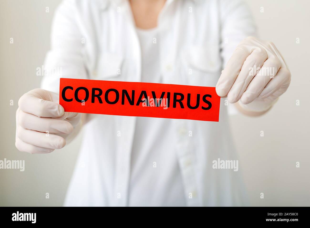 Coronavirus, red warning sign with the text Coronavirus in doctor hands in white coat and gloves. Epidemic, Chinese coronavirus 2020, Wuhan virus, Chi Stock Photo