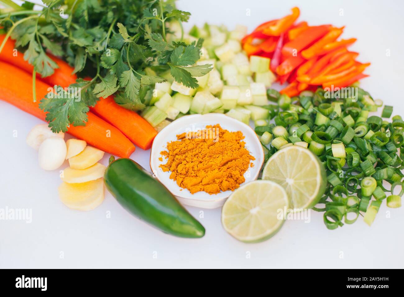 Fresh vegetable assortment on white background. Greenery, cut limes, pepper, carrot, cucumber and lime. Healthy nutrition concept. Vegeterian products Stock Photo