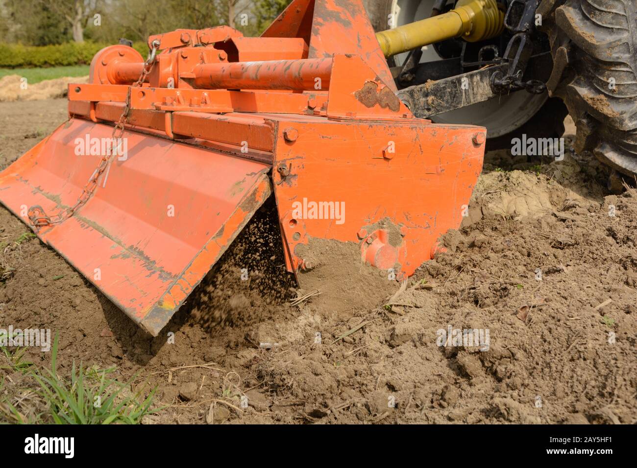 Milling machine loosens soil in the field - close-up of a rotary cultivator Stock Photo