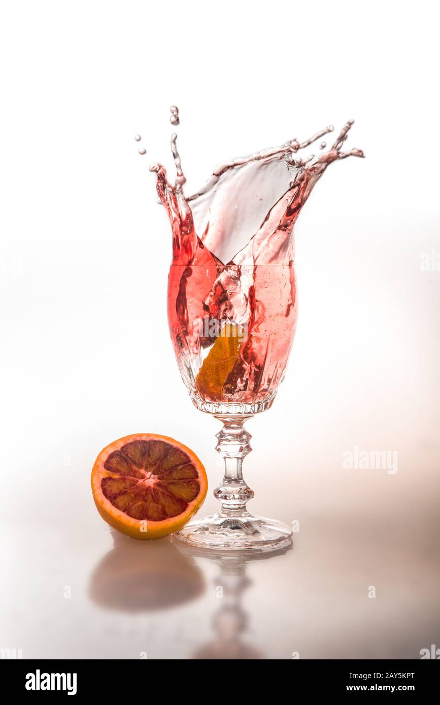 Piece of orange falling into a glass of champagne Stock Photo