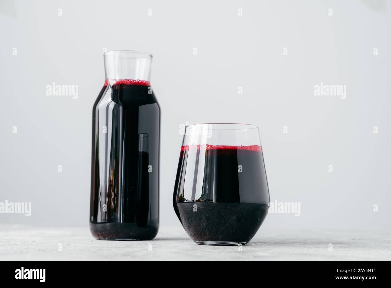 Horizontal shot of two glass containers full of fresh beetroot juice ...