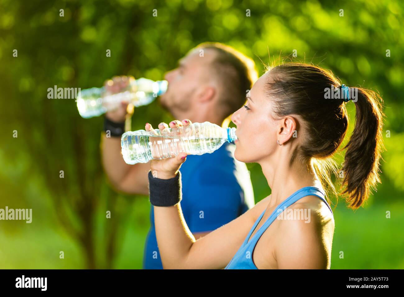 Man and woman drinking water from bottle after fitness sport exercise