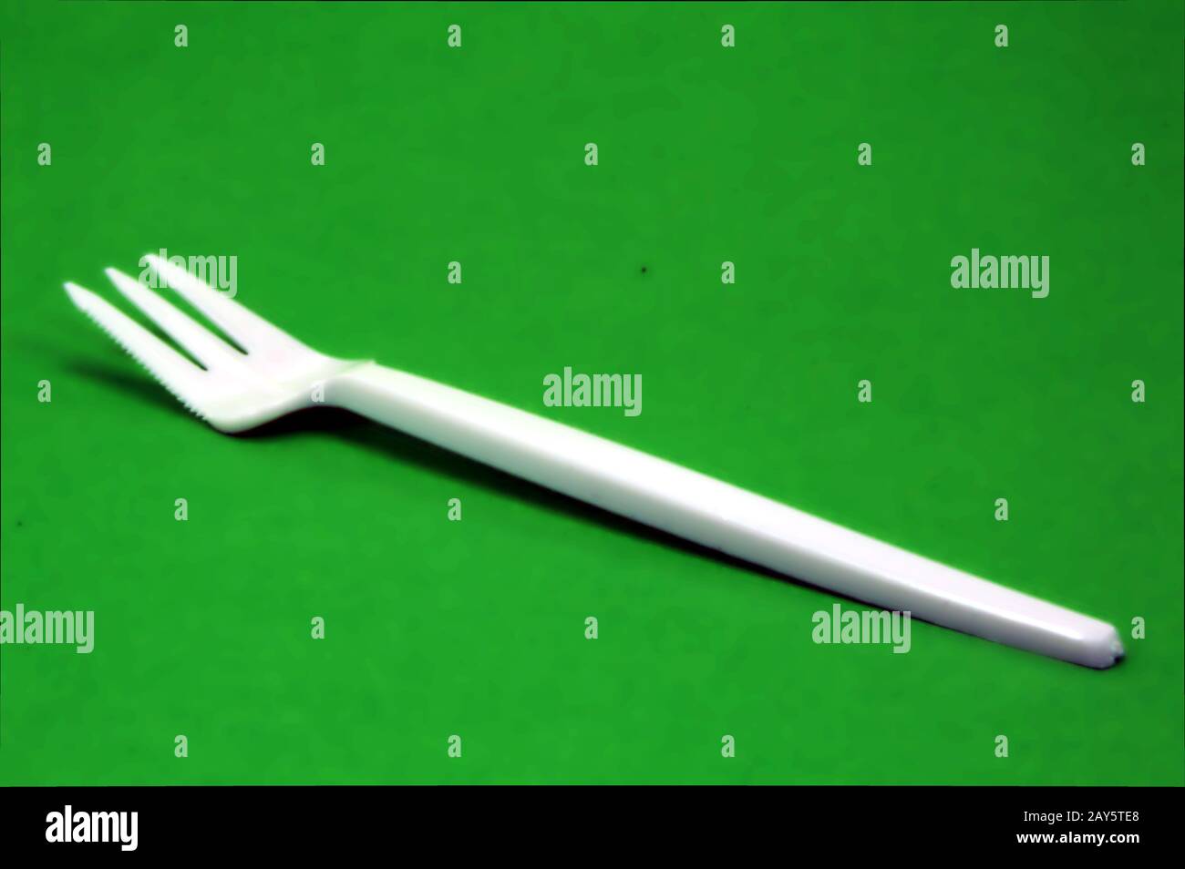 Fork white with plastic snack bar on green bottom. Stock Photo