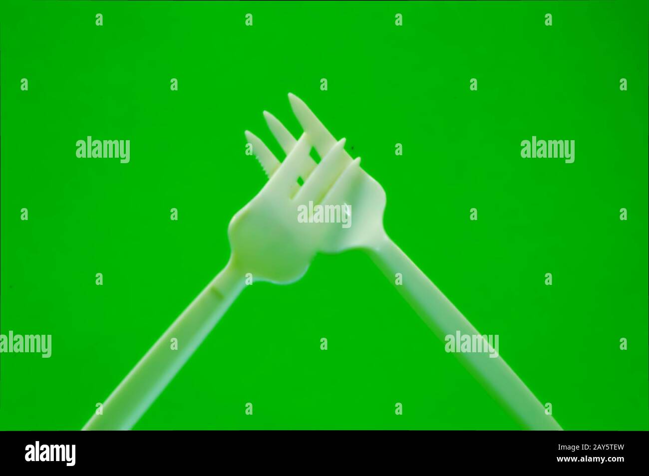 Fork white with plastic snack bar on green bottom. Stock Photo