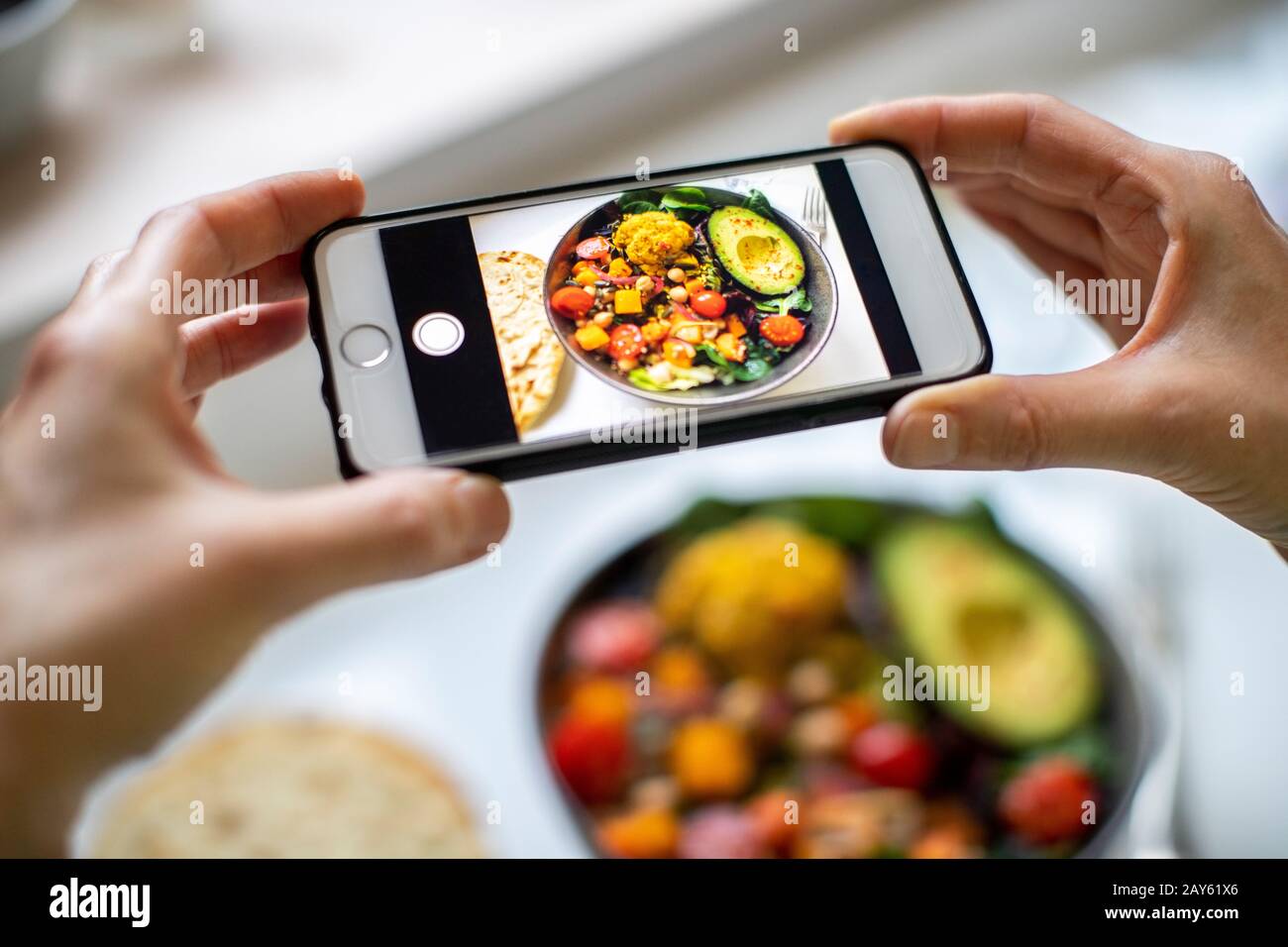 Close Up Of Woman Taking Photo Of Vegan Meal On Mobile Phone Stock Photo