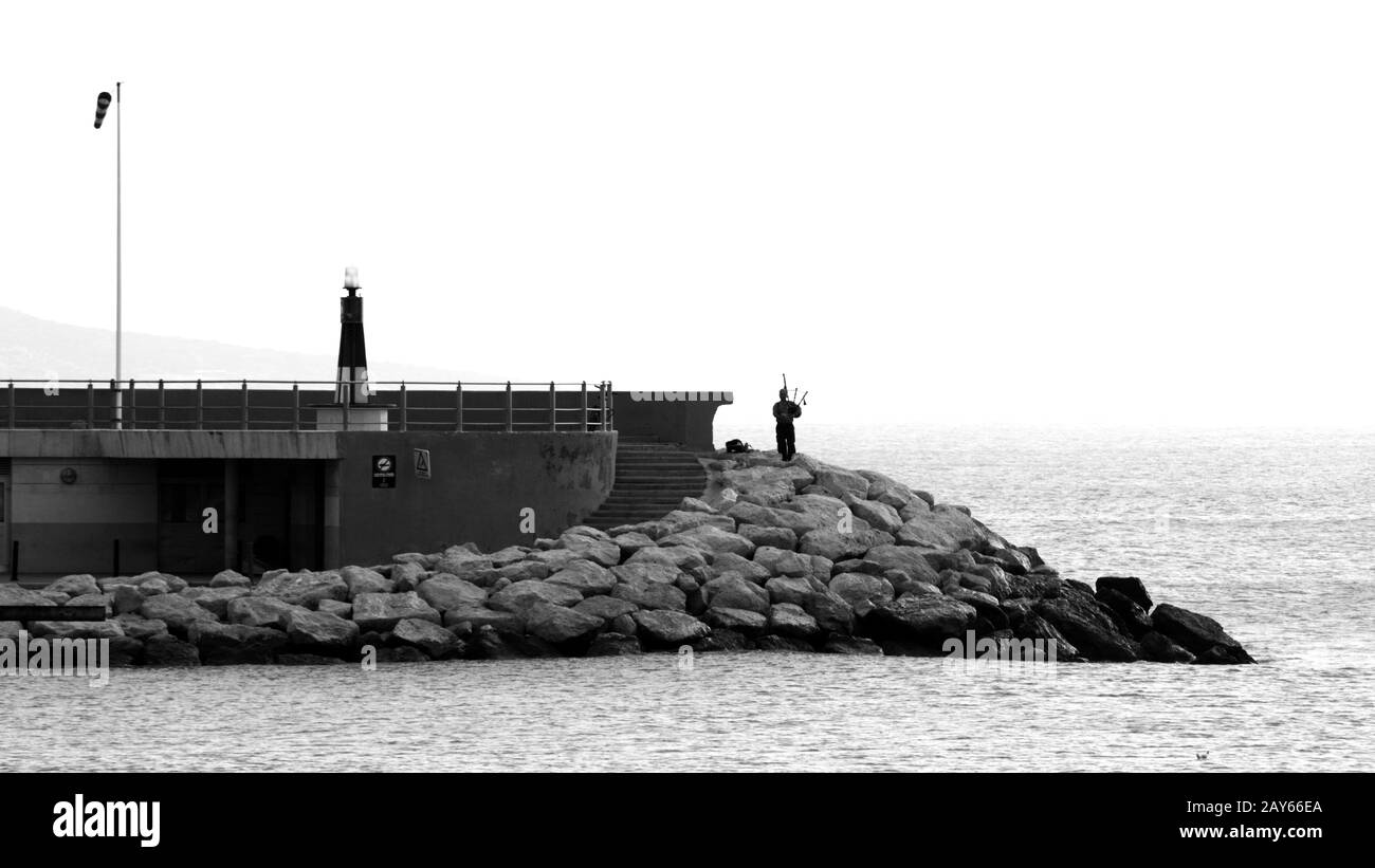 Scottish Bagpiper playing on the shoreline of Tenerife, Spain Stock Photo