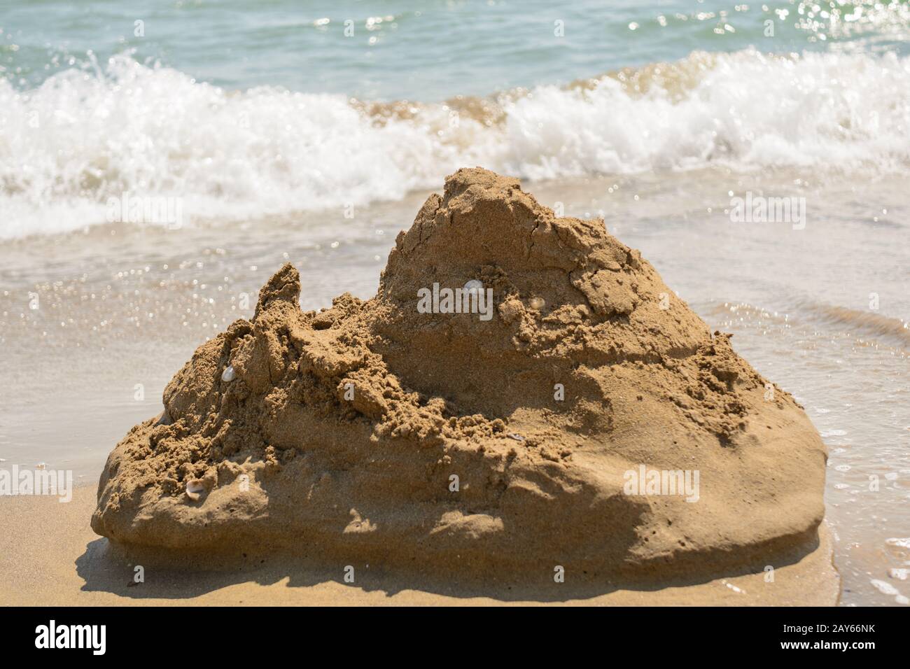 ephemeral sand castle on the sandy beach with an unquiet sea current Stock Photo