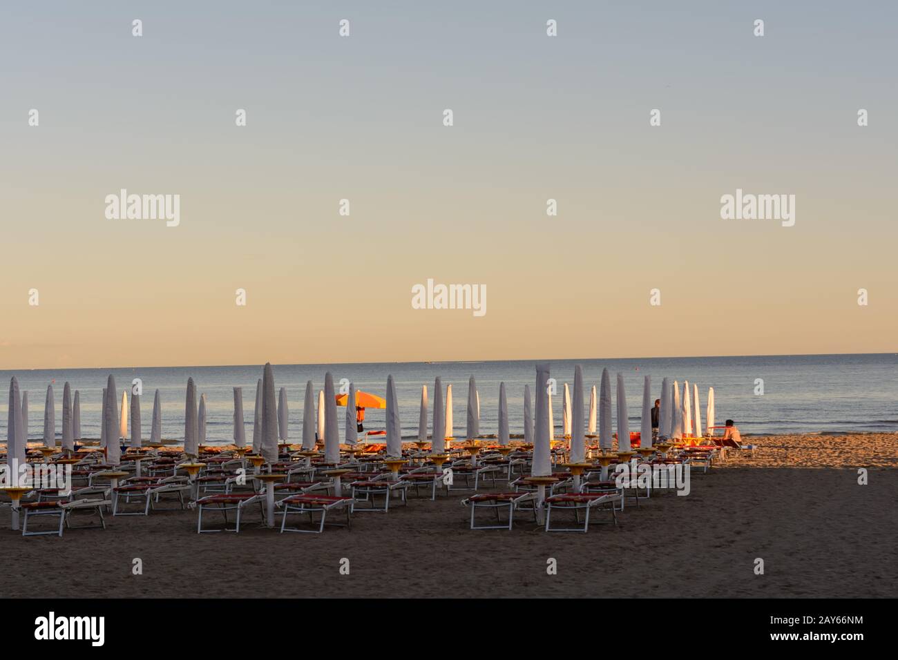 closed umbrellas and sun beds on the sandy beach in Italy Stock Photo ...