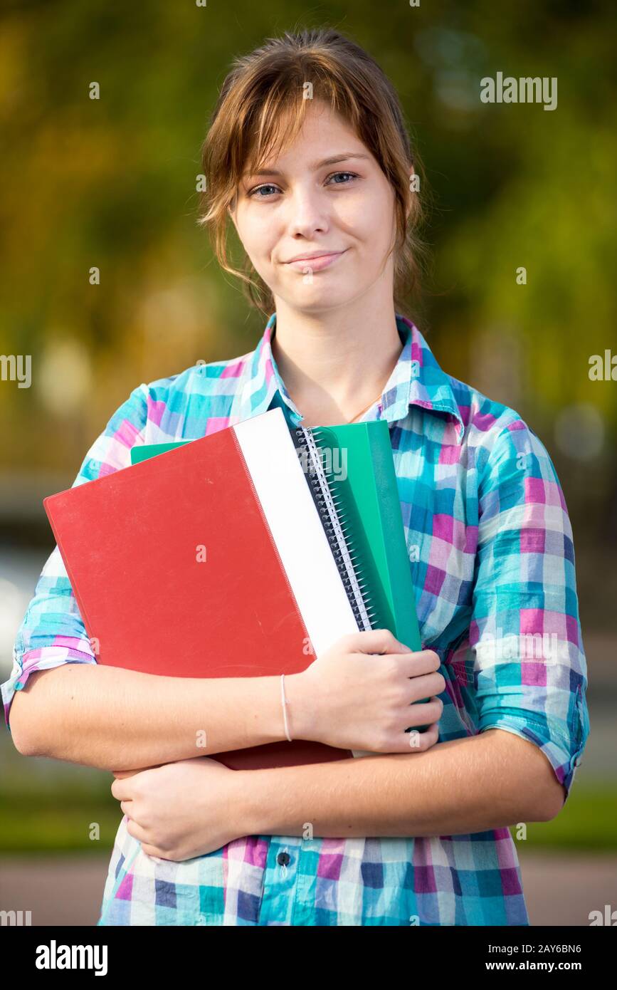 Portrait of young alluring woman holding education books. Student girl. Stock Photo