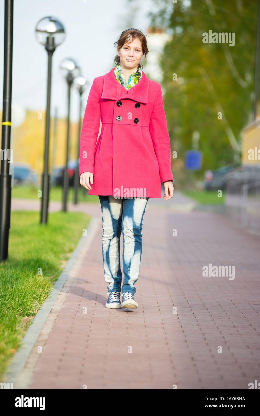 Beautiful woman in red coat walking autumn street. Stock Photo