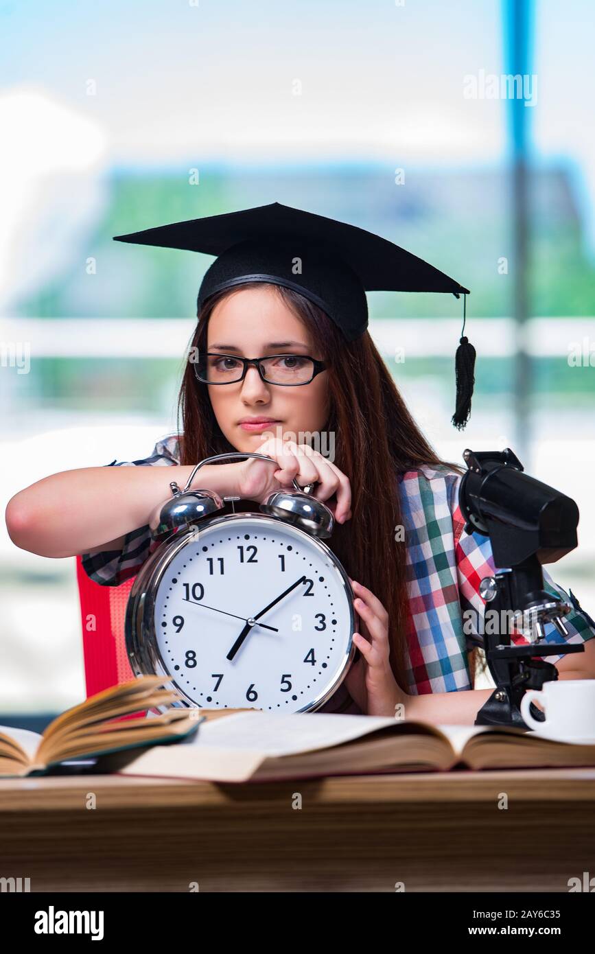 Young girl preparing for exams with large clock Stock Photo Alamy