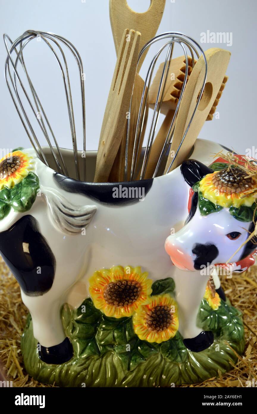 Distort cow with the hollow back and the kitchen utensils on a white bottom Stock Photo