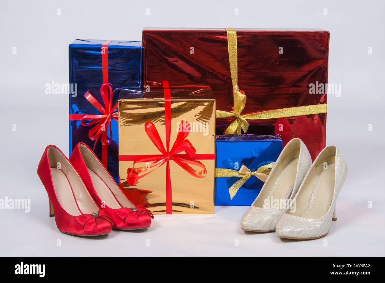 Red and white female shoes with high heels, standing near boxes with gifts Stock Photo