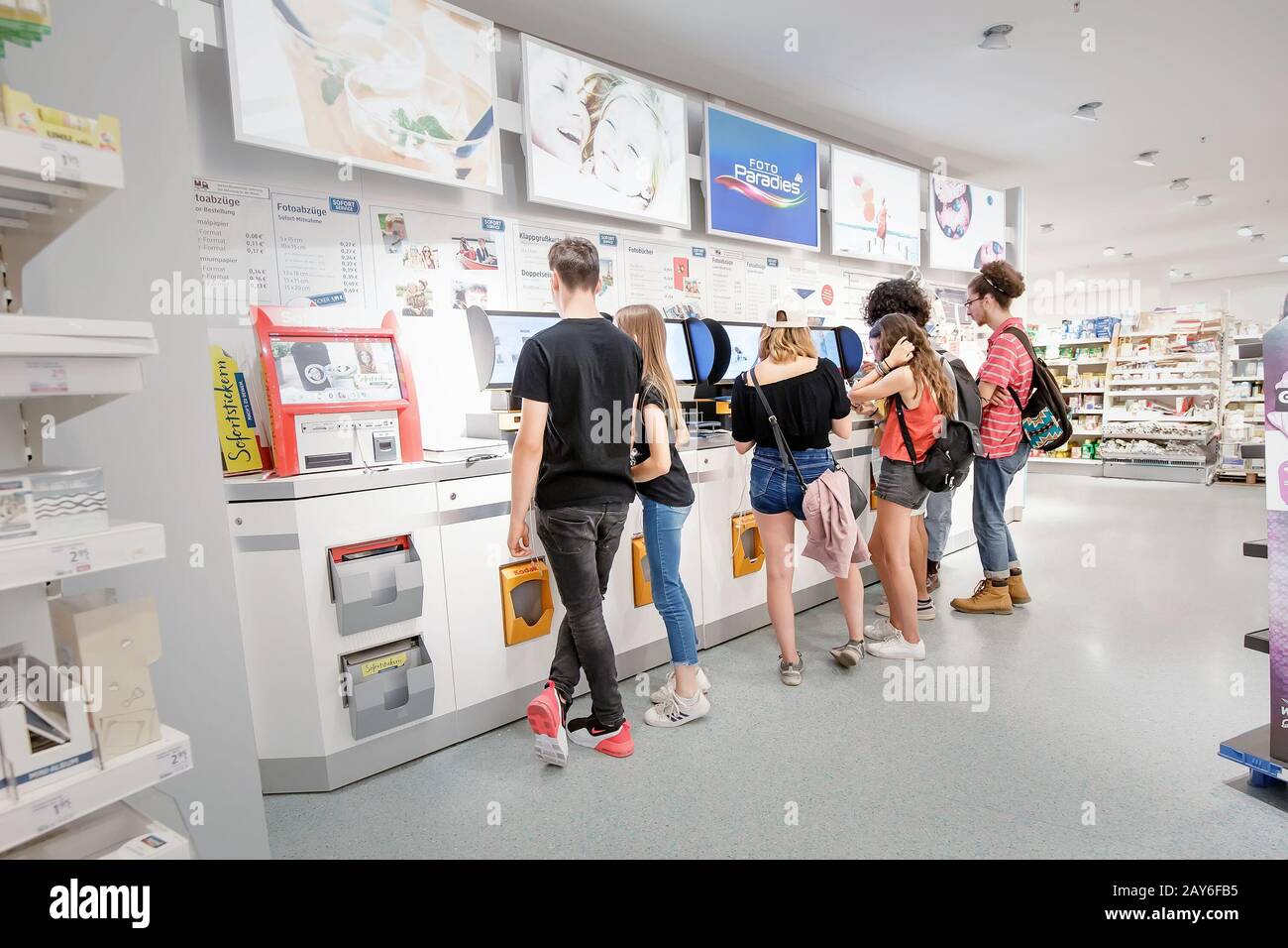 02 August 2019, Saarbrucken, Germany: People print photos with a smartphone in a special compartment in the store Stock Photo