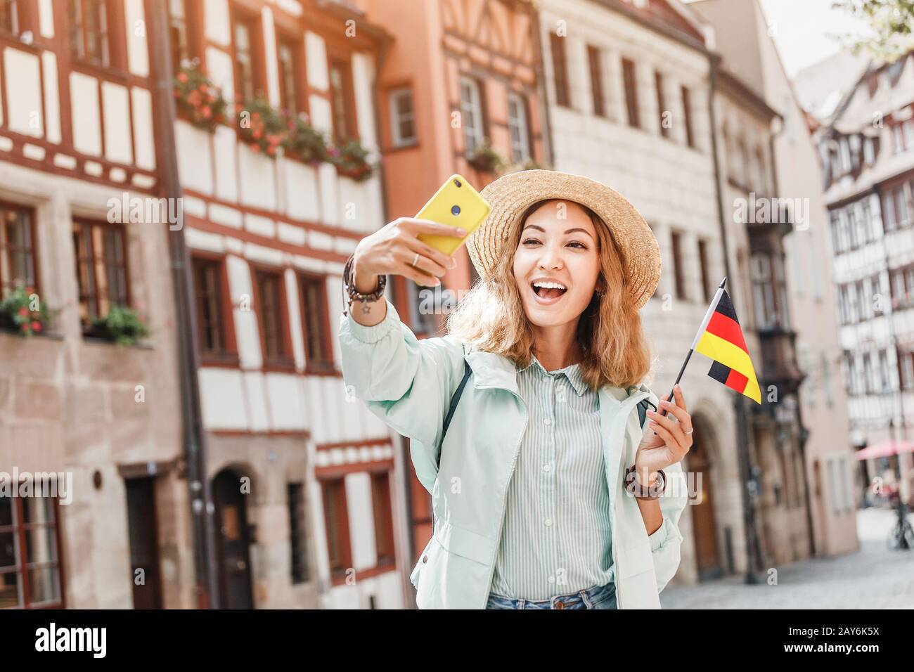 Young asian woman tourist taking selfie photo with german flag near the