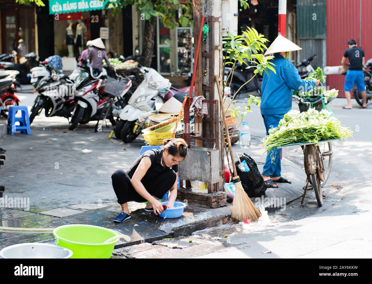 Vietnamese woman washing dishes on the roadside in Hue, Vietnam Stock Photo