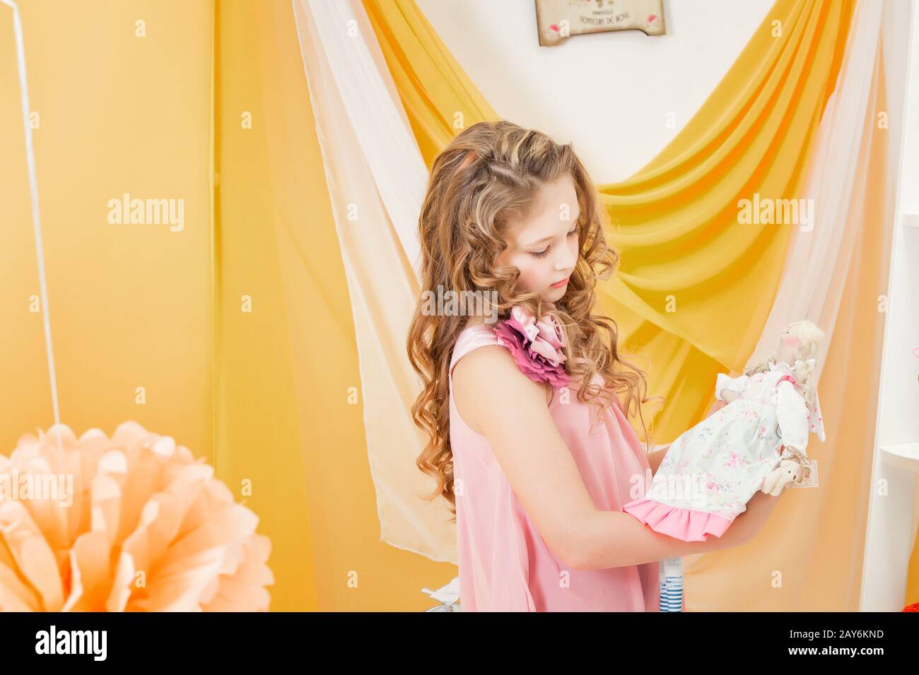 Little girl playing with doll in retro interior Stock Photo - Alamy