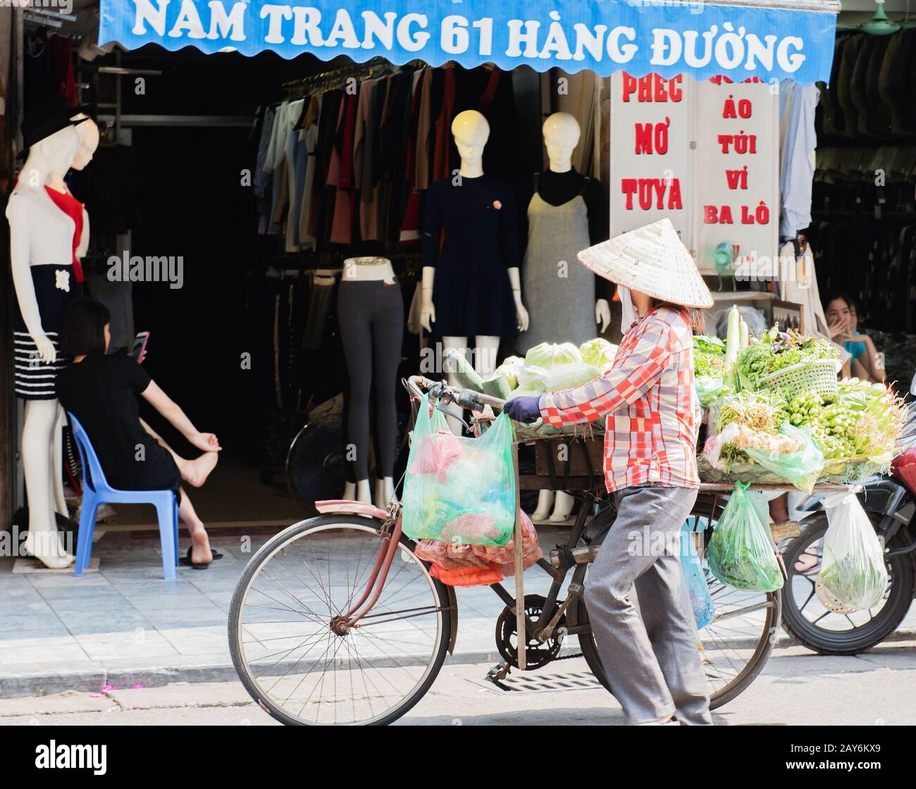 Vietnamese street vendors act and sell their vegetables and fruit products in Hanoi, Vietnam Stock Photo