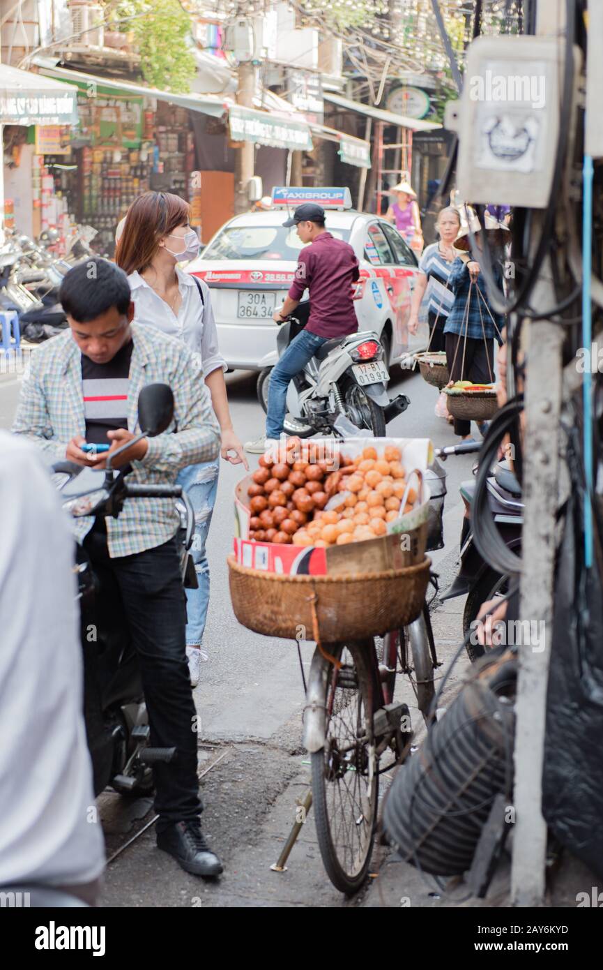 Vietnamese street vendors act and sell their vegetables and fruit products in Hanoi, Vietnam Stock Photo