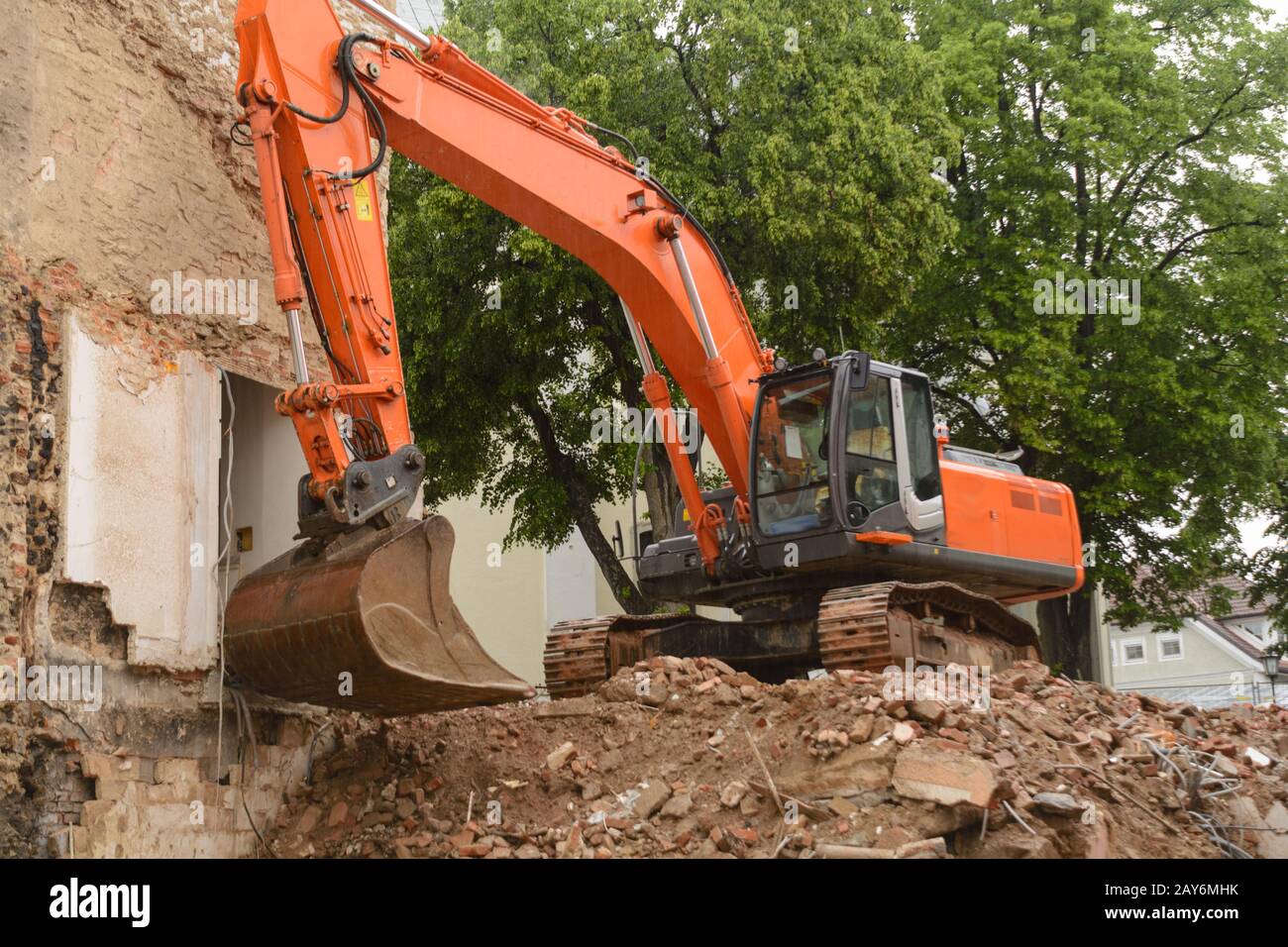 Demolition of a house by a bucket excavator - Building site renovation of an old house Stock Photo