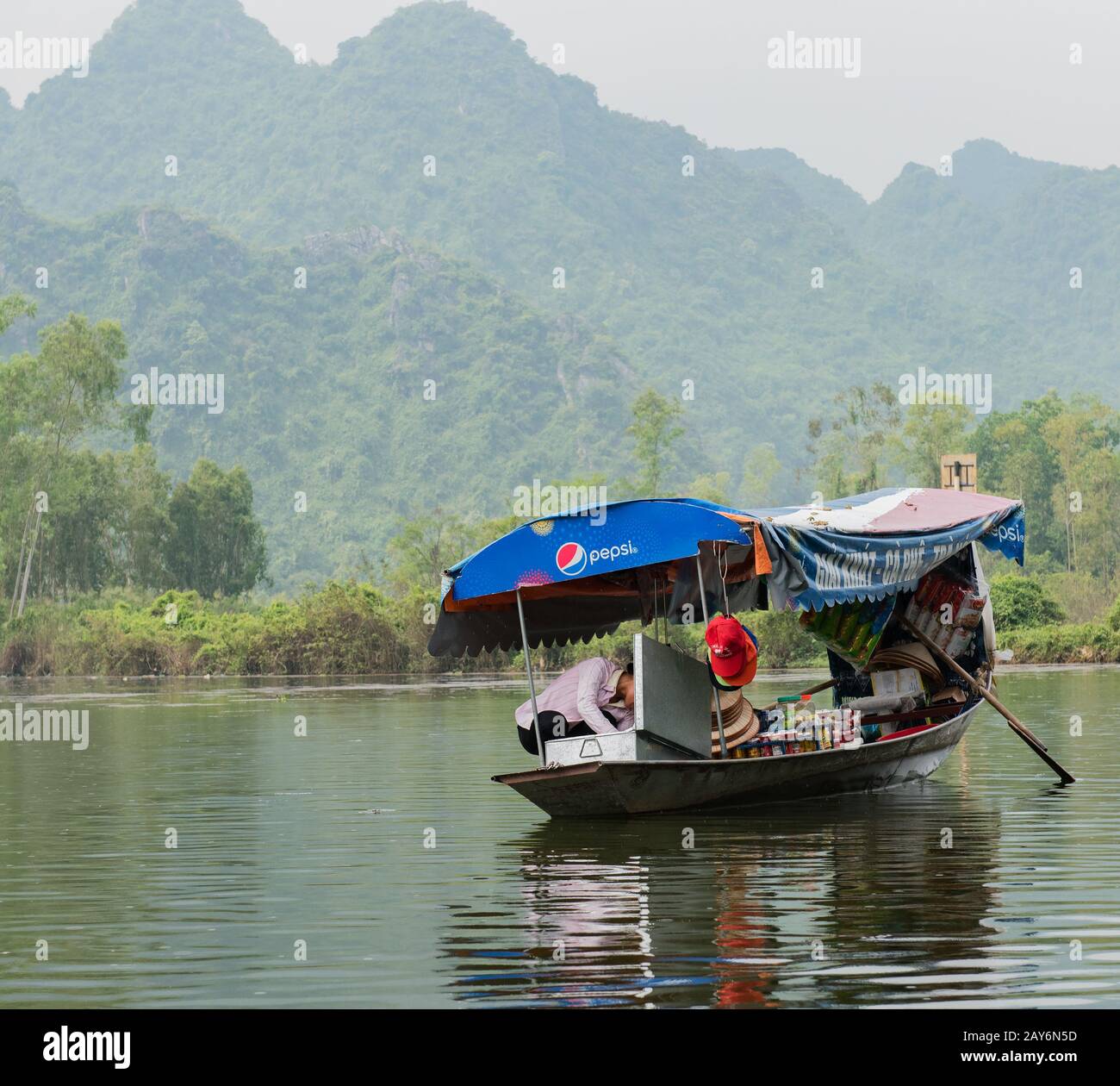 Vietnamese souvenir seller selling on a boat at the Red River in Hanoi, Vietnam Stock Photo