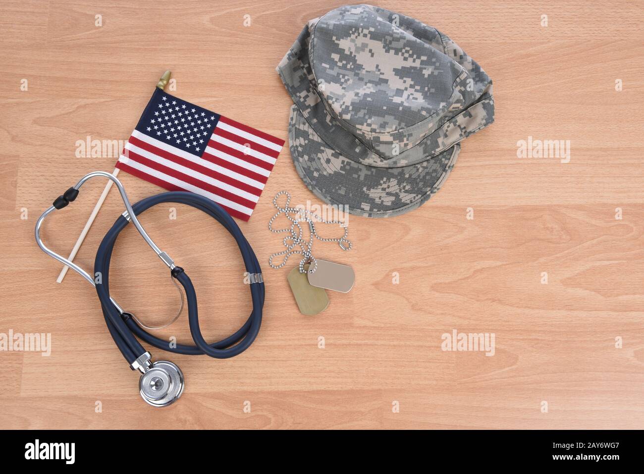 Military Health Care Concept. Light wood background with stethoscope, American flag, camo hat, and dog tags. Stock Photo