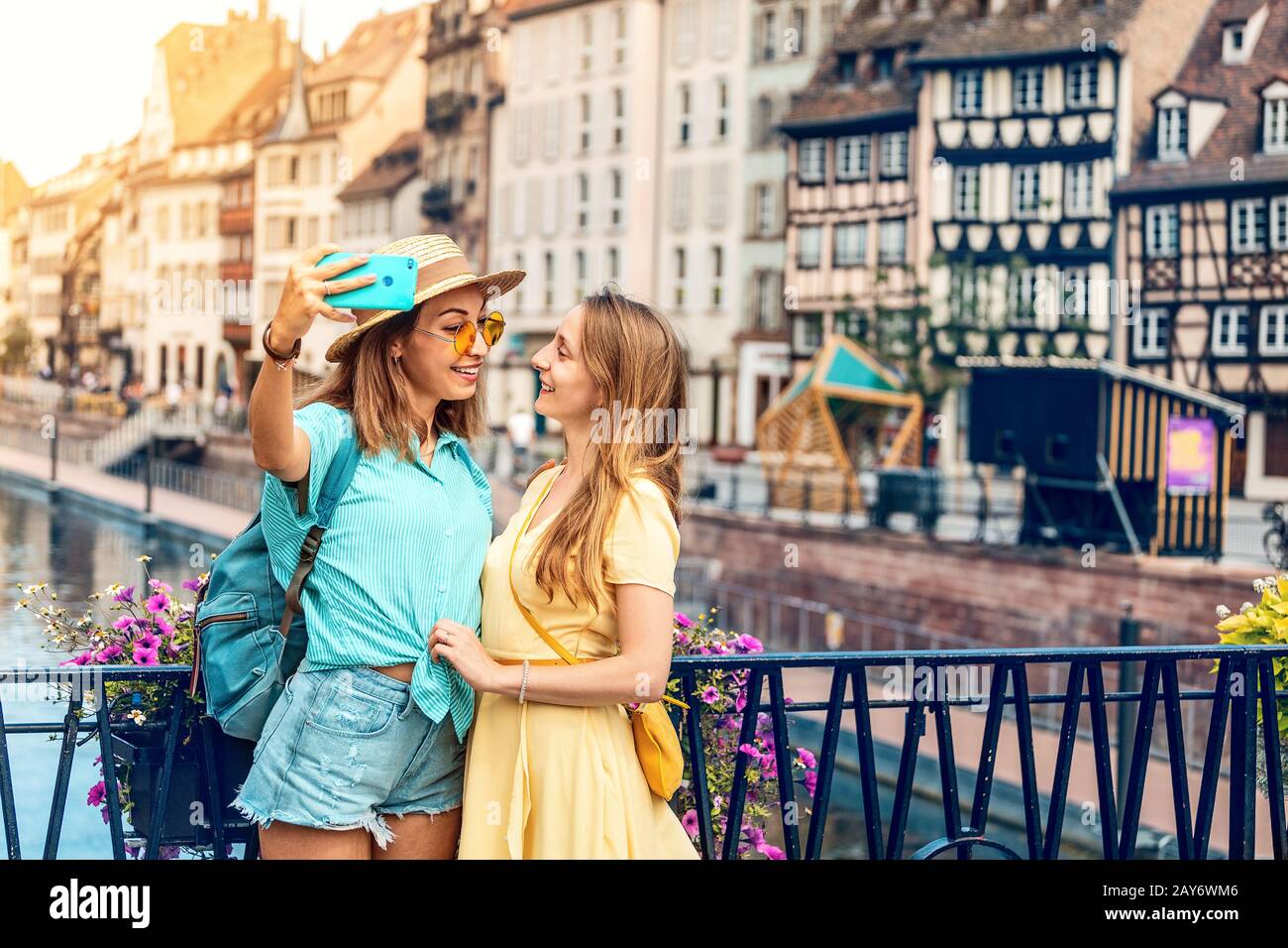 Two multicultural girl friends take a selfie on smartphone while traveling in European old cities. Vacation and relationship concept Stock Photo