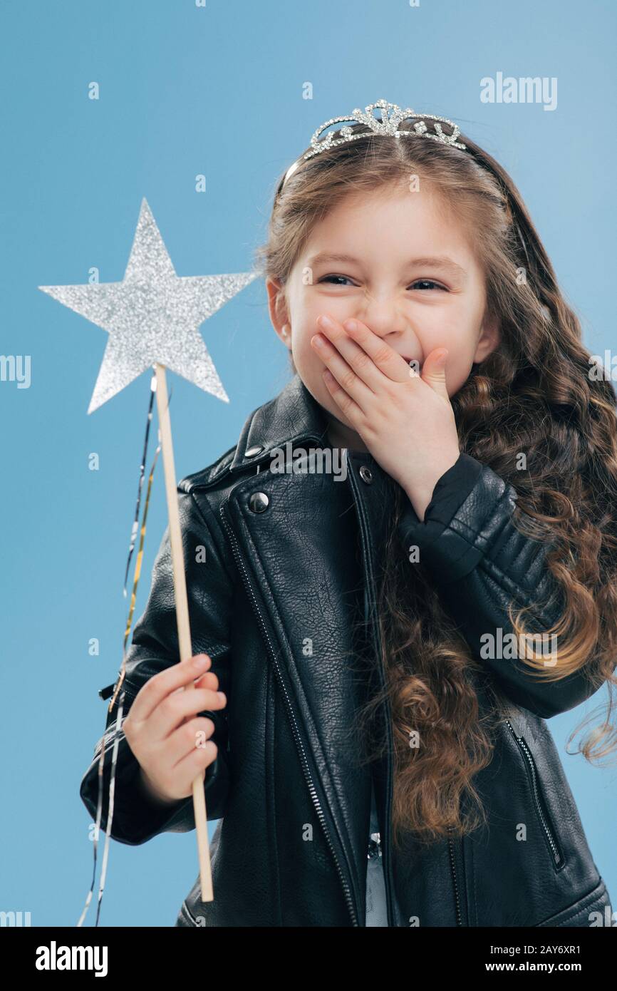 Overemotive positive small child covers mouth with one palm, wears