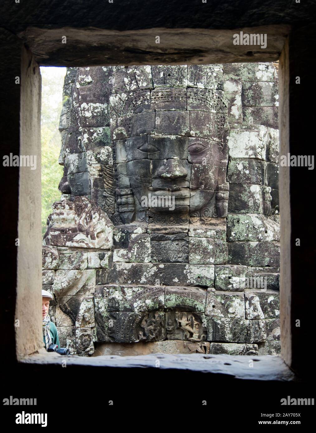 Blick durch eine Öffnung auf eine Gesichter-Säule im Bayon, Angkor, Kambodscha Stock Photo