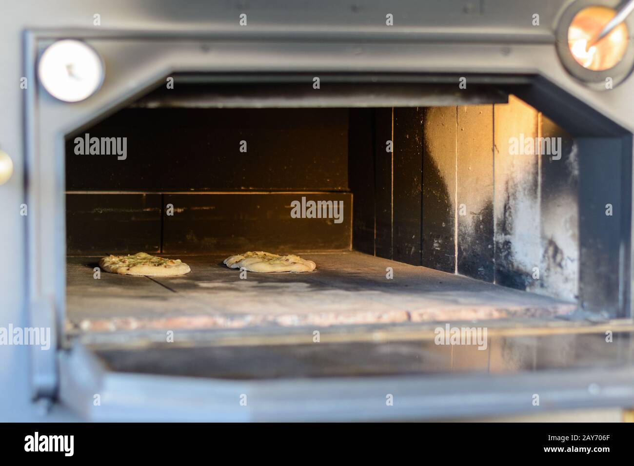 Pizzas in an old oven - close-up view into a large open oven Stock Photo