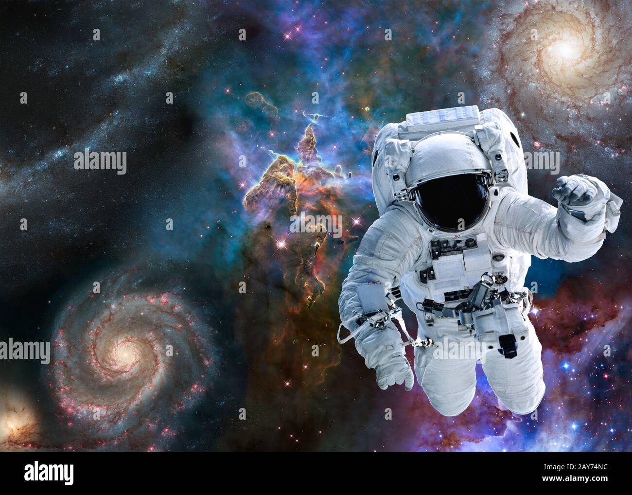 Astronaut near Mystic Mountain of Carina Nebula near far galaxies and stars. Science fiction. Elements of this image were furnished by NASA. Stock Photo