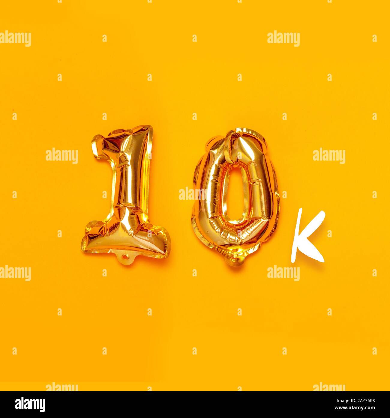 10,000 gold sign balloon on a yellow background. Subscribe concept ...