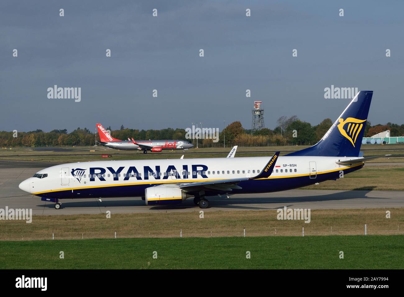 Ryanair plane taxing for departure as a Jet2 plane departs in the background at London Stansted Airport Stock Photo