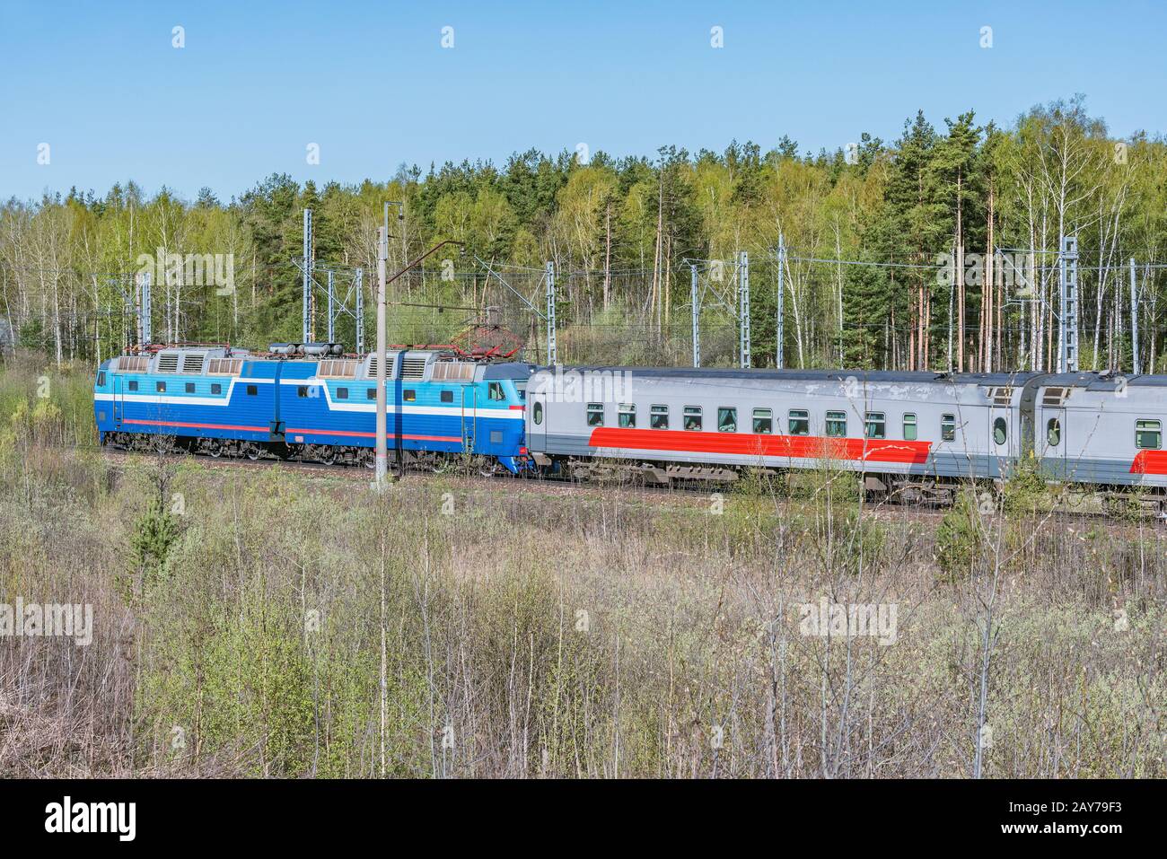 Passenger train moves on the forest background at spring day time Stock ...