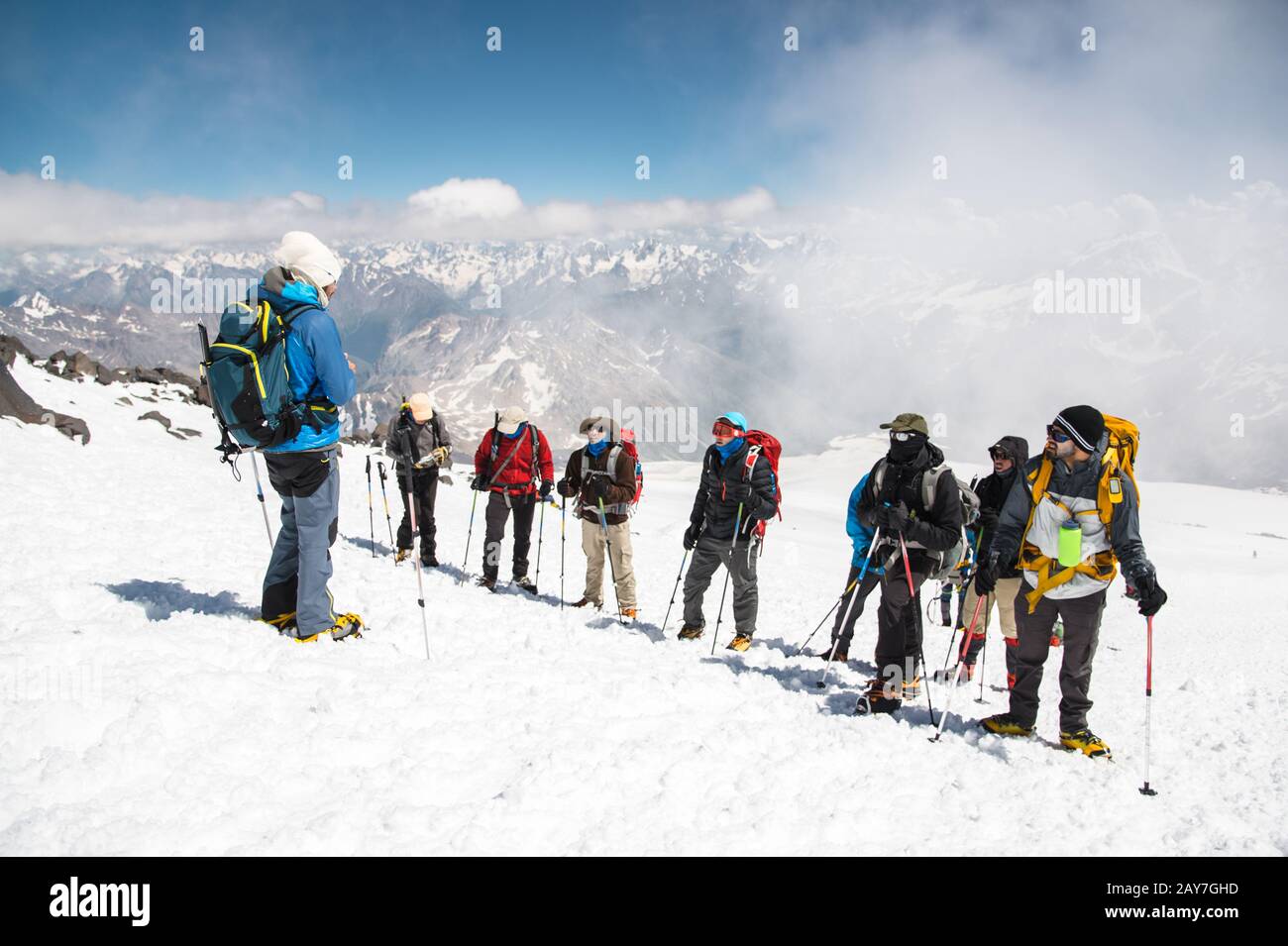 A team of climbers led by a guide discusses the upcoming ascent Stock Photo