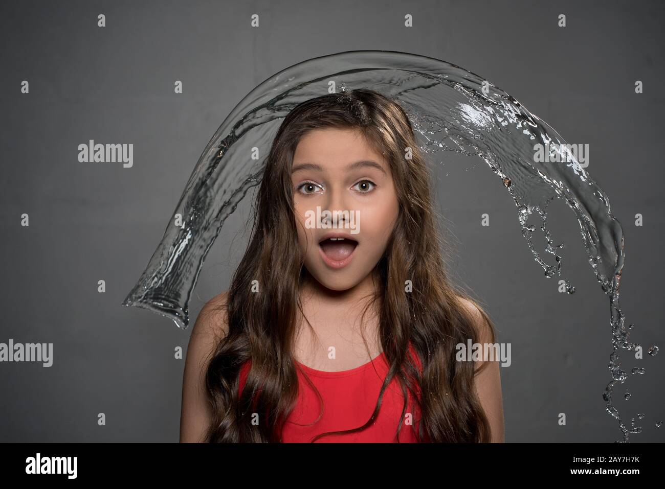 Teenaged surprised girl and water pouring over her Stock Photo