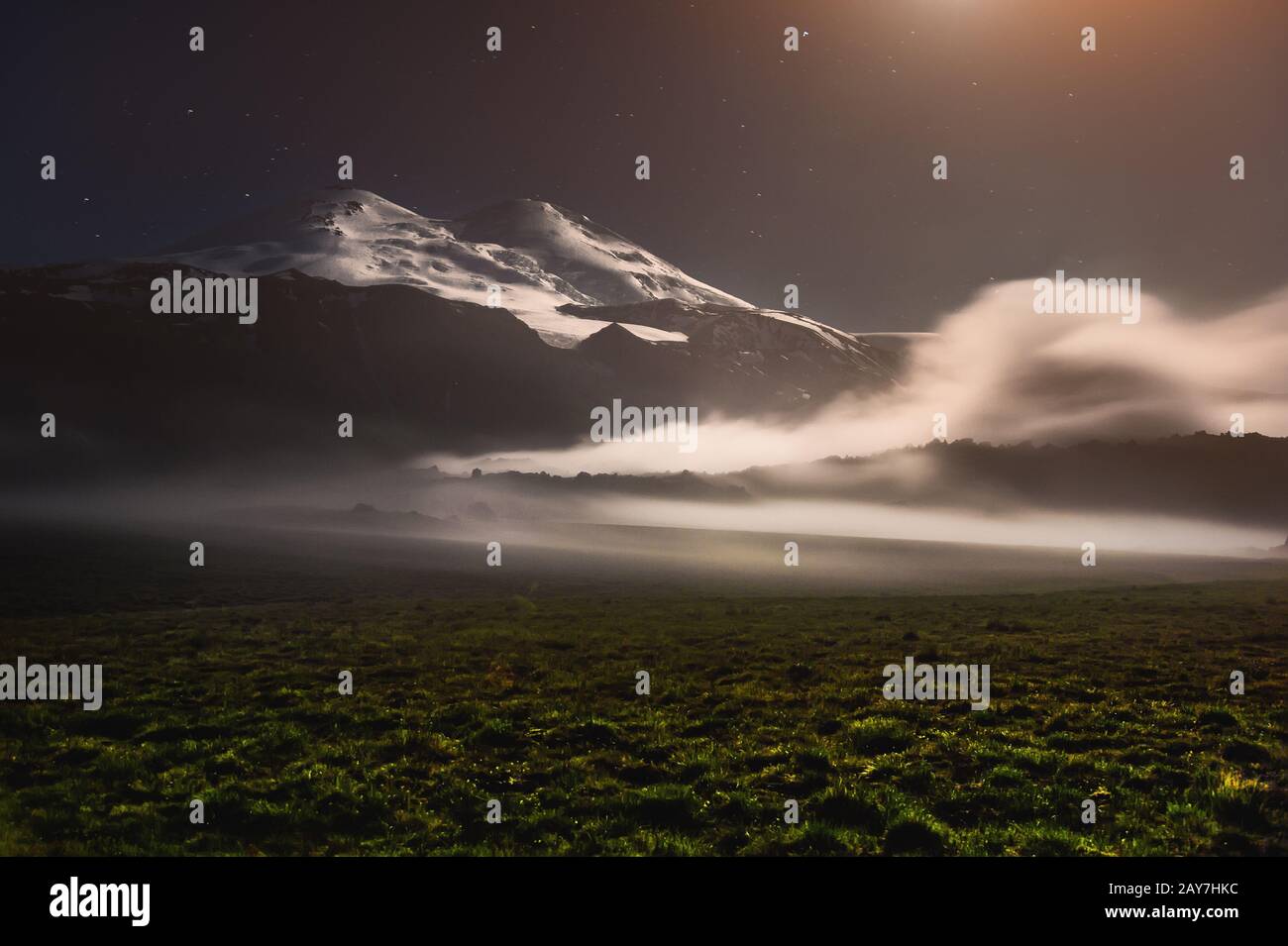 A floating cloud in the vicinity of the sleeping Elbrus volcano in the Caucasus at night in the light of the moon Stock Photo