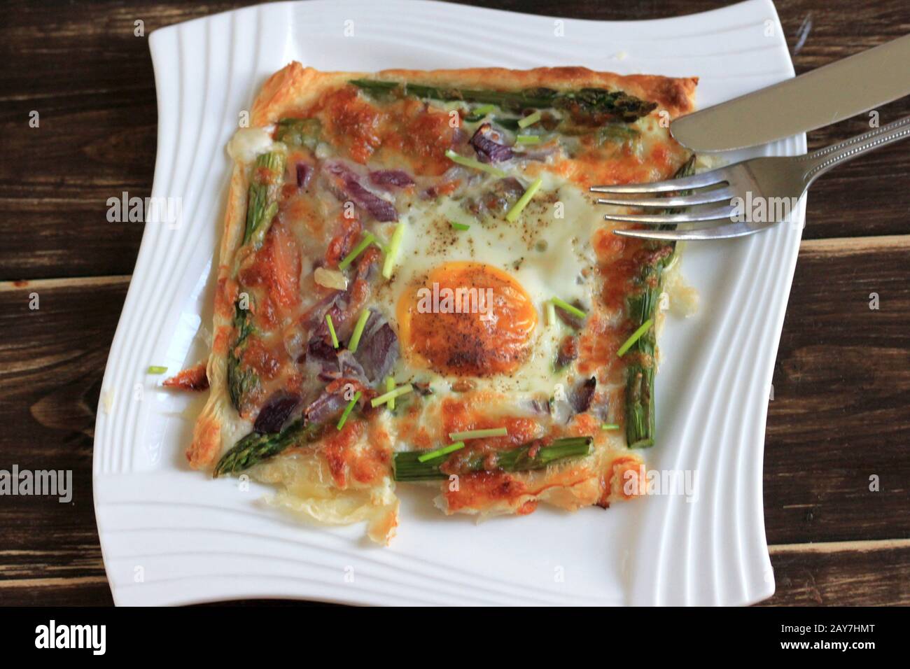 A delicious and tasty snack. Puff pastry with salmon, egg and asparagus . Stuffed puff pastry, quick snack. Delicious breakfast. Stock Photo