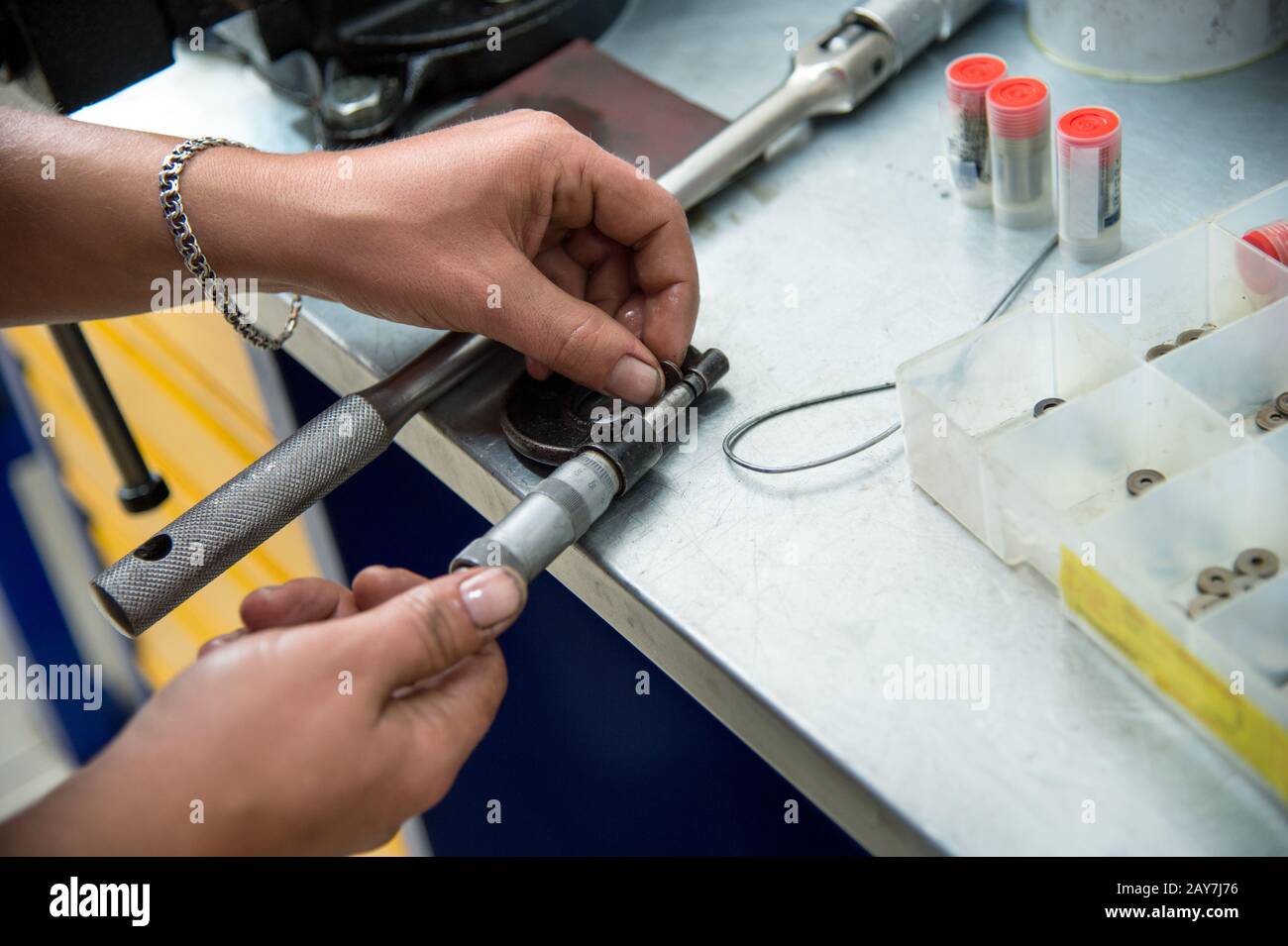 Men's hands measure a micrometer special compression washers to adjust