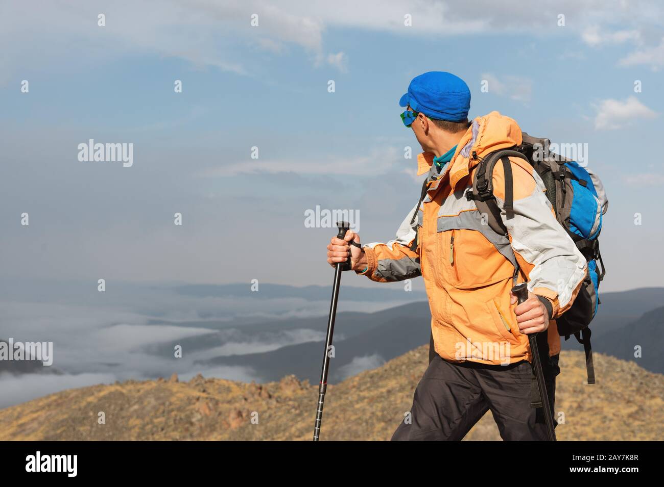 A lonely tourist enjoys the views high in the mountains where there is no grass of the village and snow Stock Photo