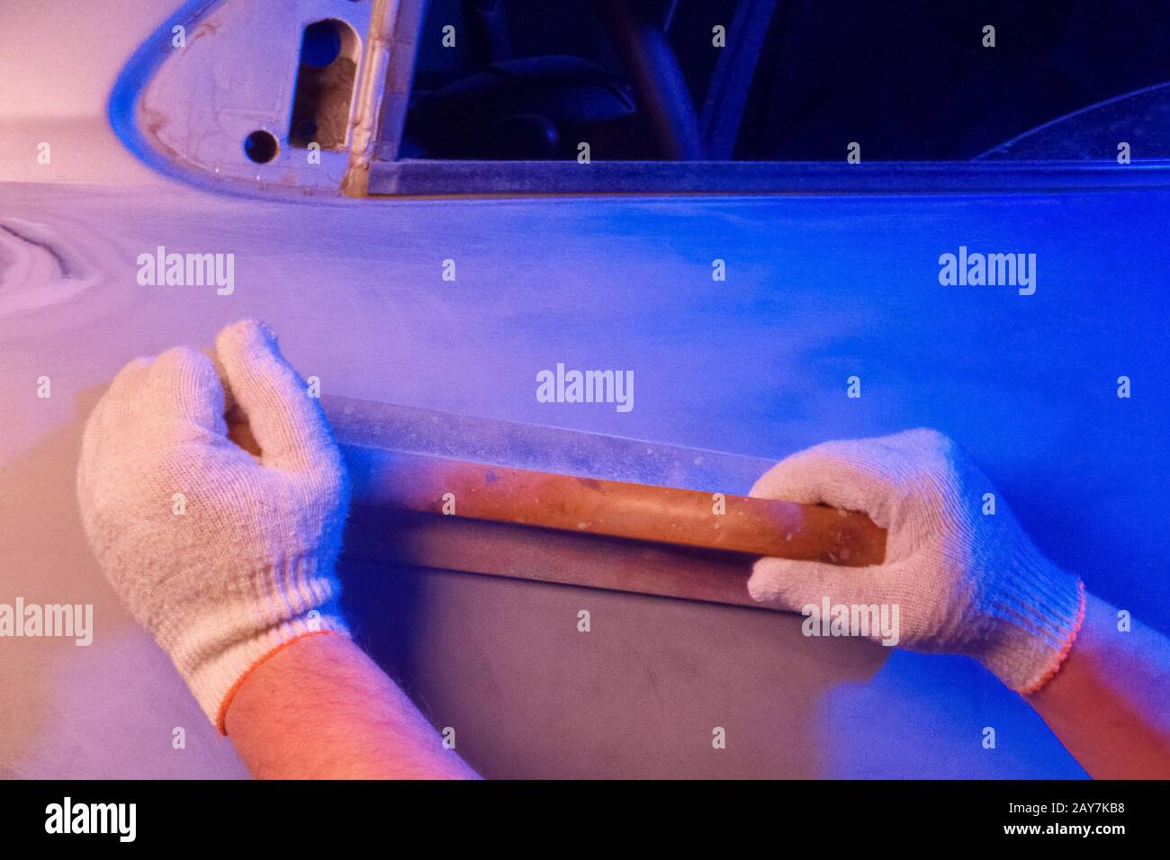 Car body repair, grinding parts with a hand tool in garage conditions