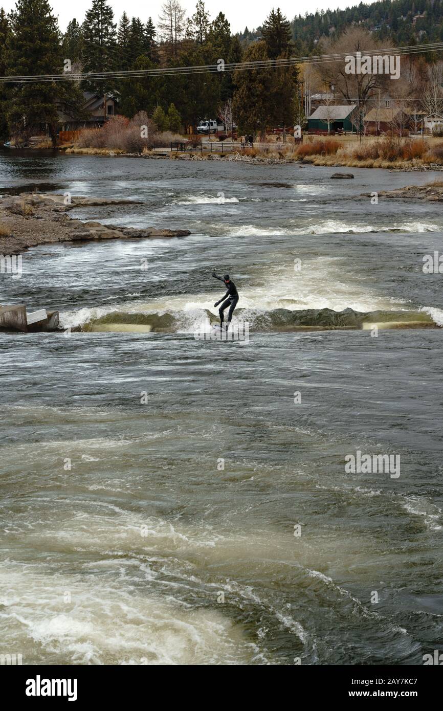 River surfing in the Deschutes River at the Bend White Water Rapid Park in Bend Oregon. Stock Photo