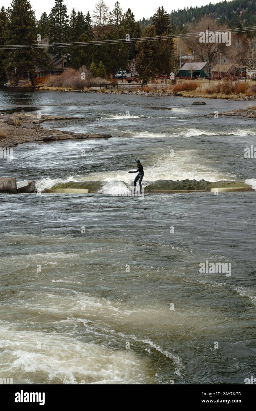 River surfing in the Deschutes River at the Bend White Water Rapid Park in Bend Oregon. Stock Photo