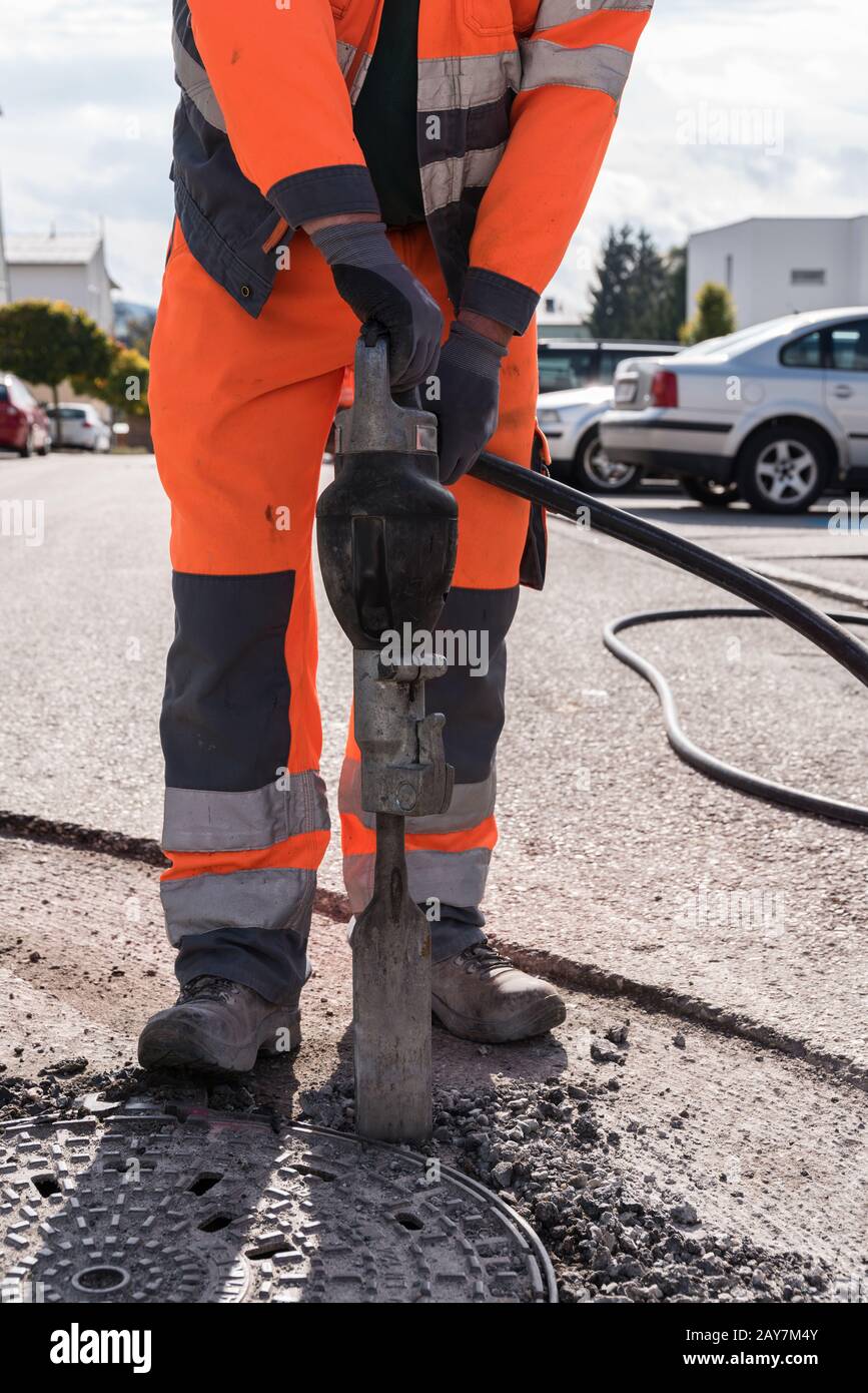Worker with a caulking hammer on a construction site closeup Stock