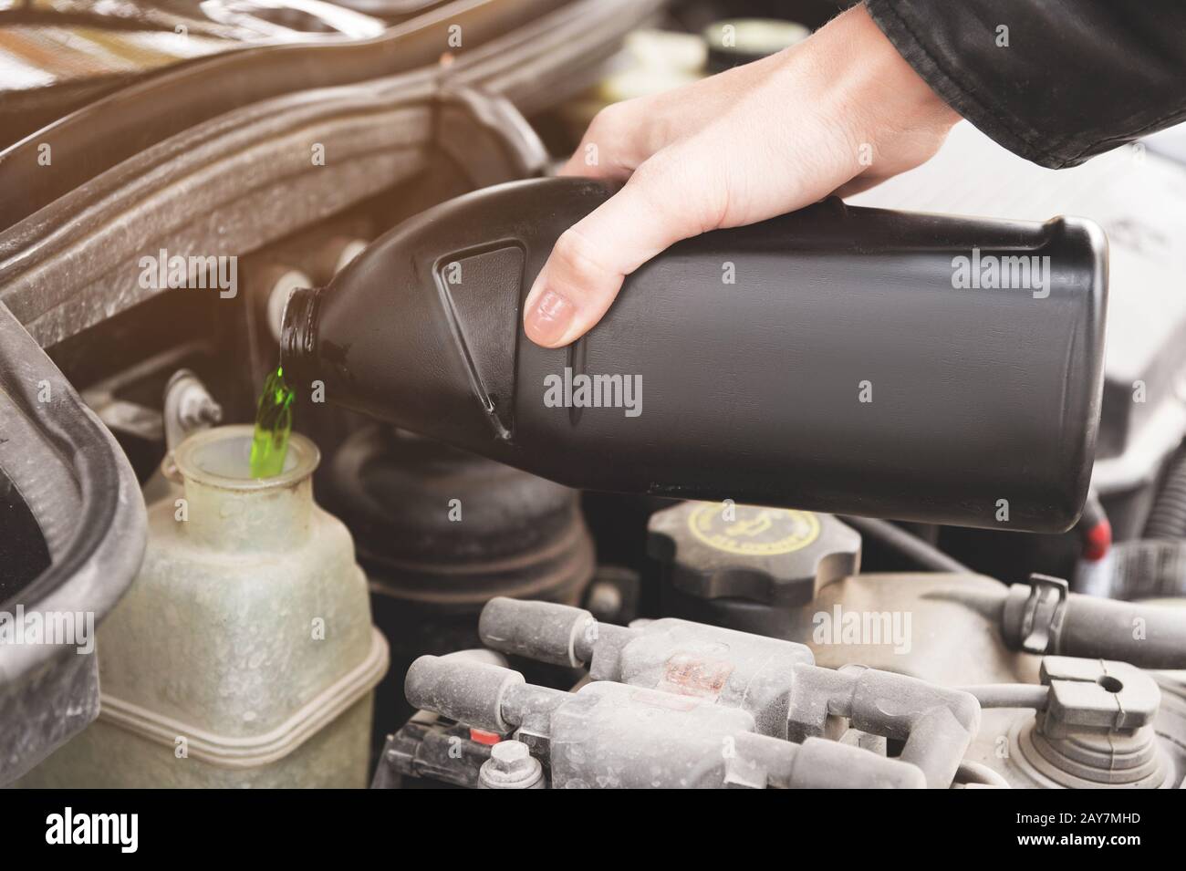 Close up girl checks the level of coolant in the engine of her car Stock Photo