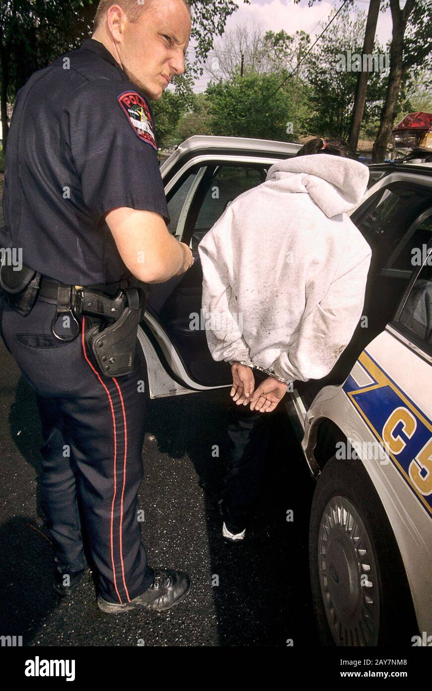 Austin, Texas USA, 2997: Police officer apprehends juvenile.  ©Bob Daemmrich Stock Photo