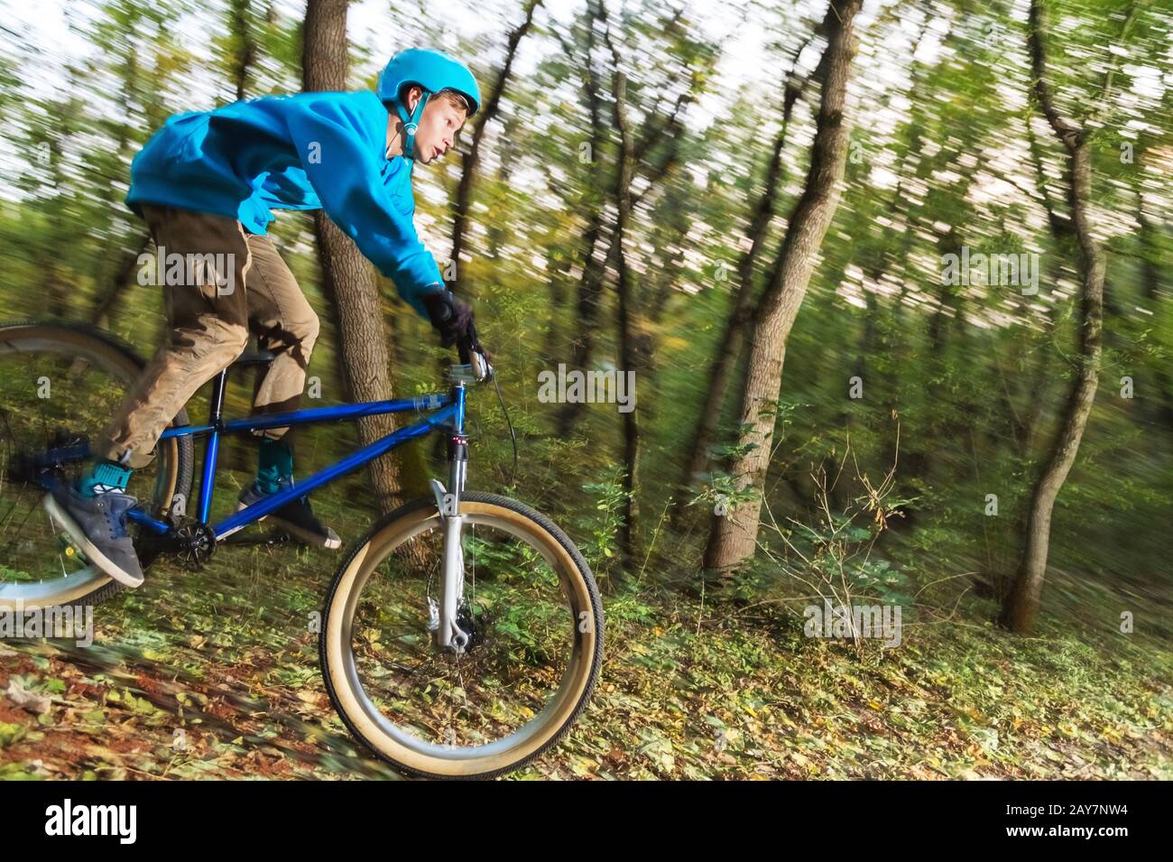a young guy in a helmet flies landed on a bicycle after jumping from a kicker Stock Photo