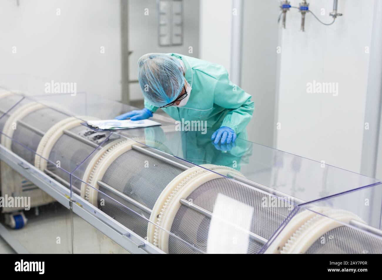 scientist is making notes about a machine Stock Photo