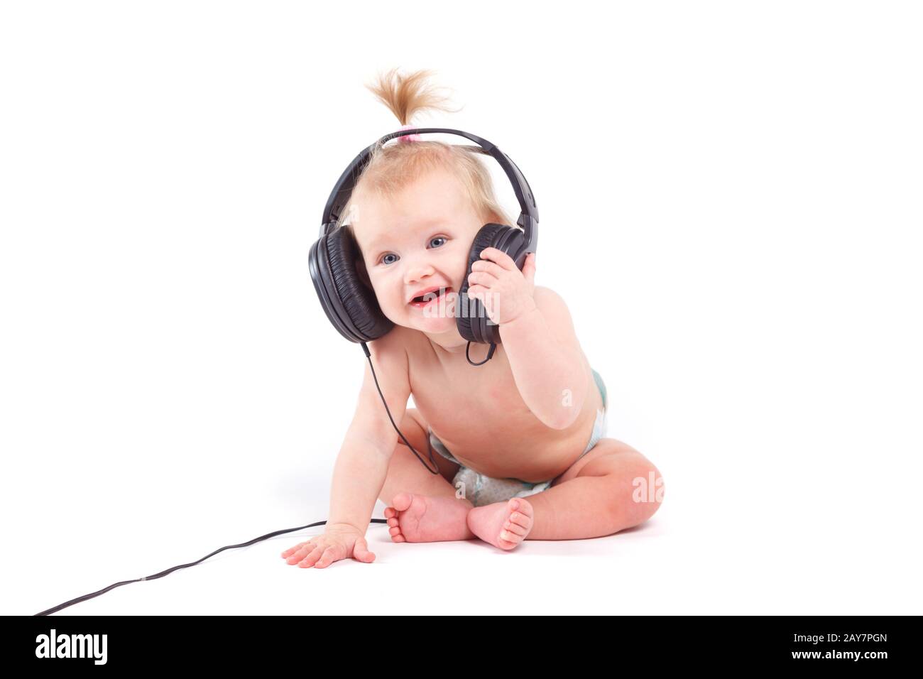 cute pretty baby girl in white diaper with headphones Stock Photo