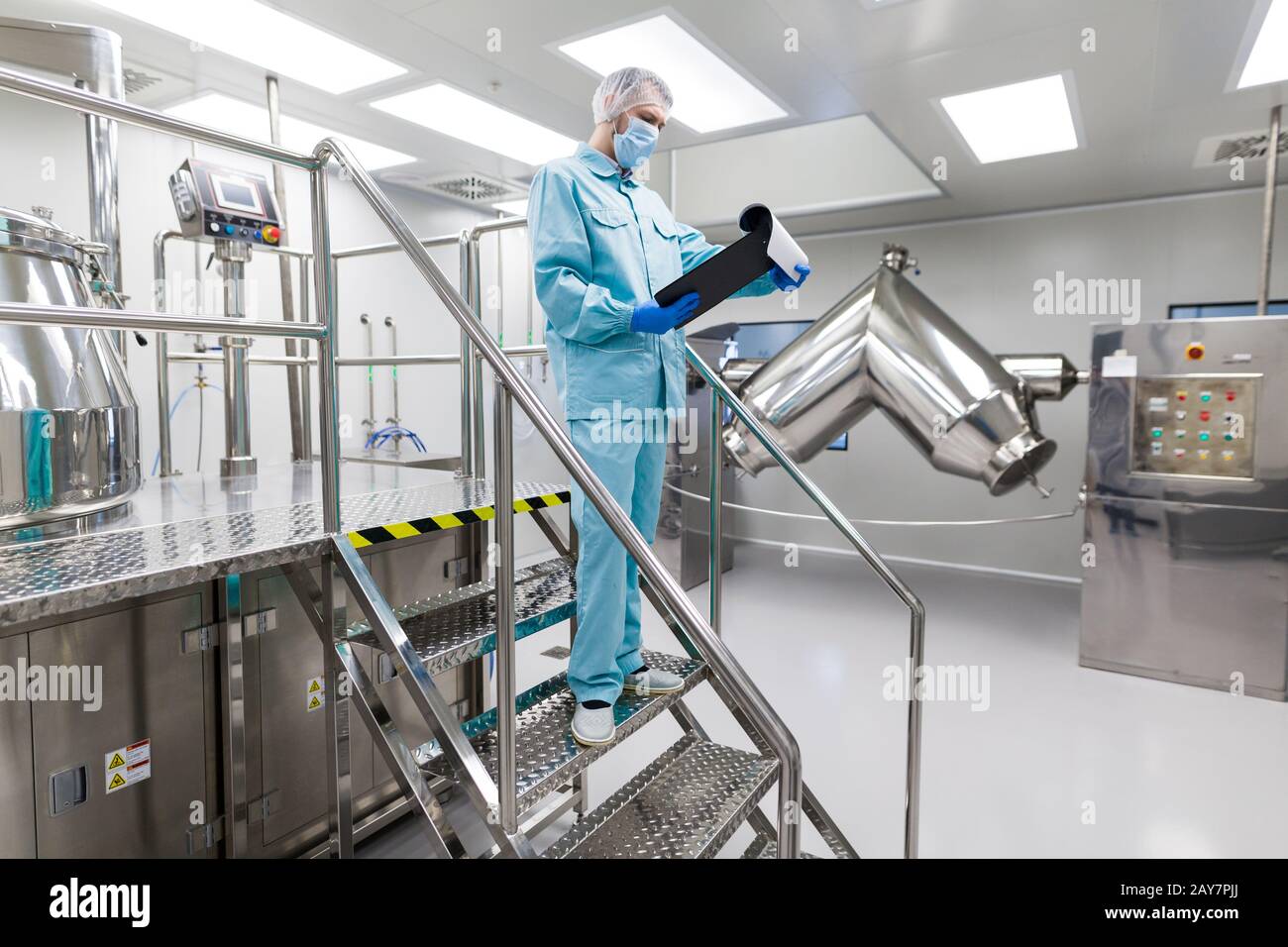plant picture, scientist is standing on ladder in laboratory, checking readings Stock Photo